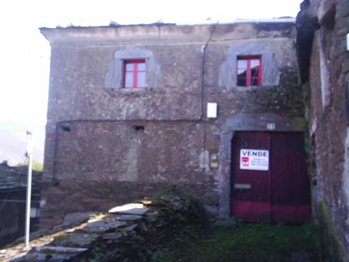 Vista de la casa en la que se muestra una entrada y las dos ventanas de la parte superior.