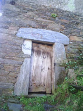 Detalle de la casa de piedra, en la que se muestra una puerta. 